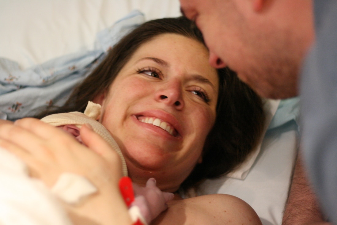 Another happy doula client, finally holding her baby in her arms.